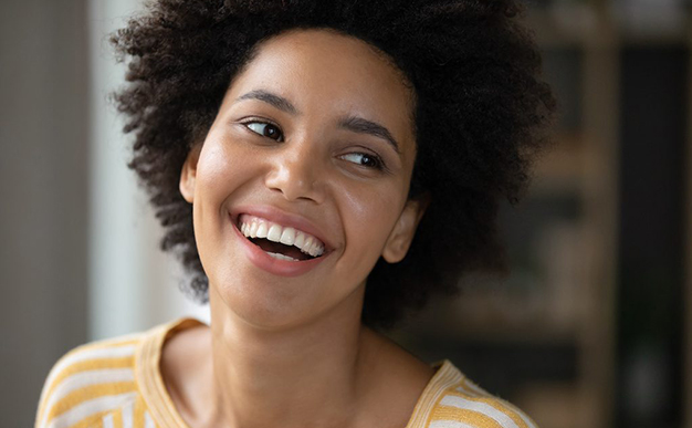 Smiling woman in yellow striped shirt, dental care professional portrait for West River Dental Care.