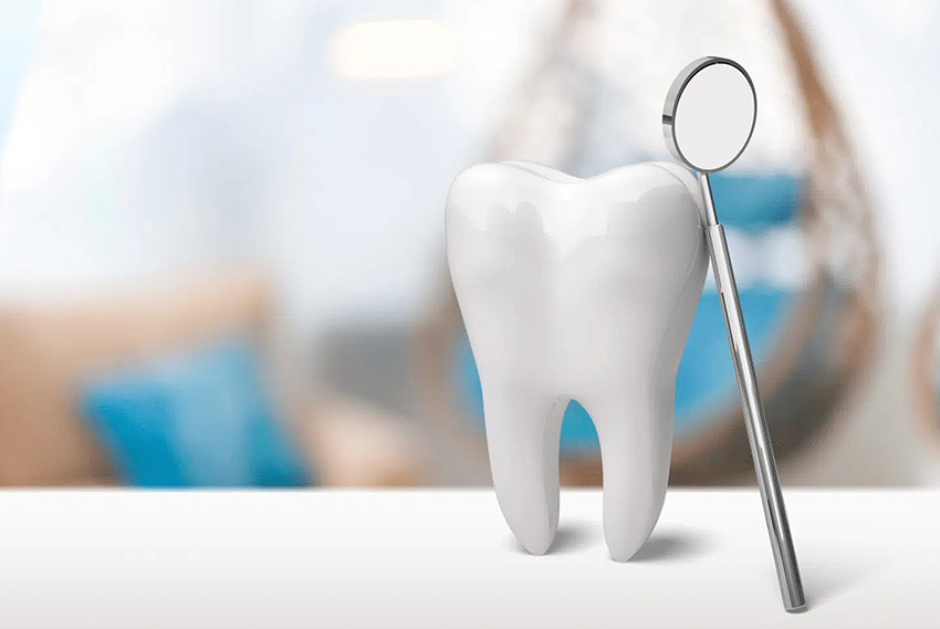 Dental mirror beside white tooth model in professional dental office setting