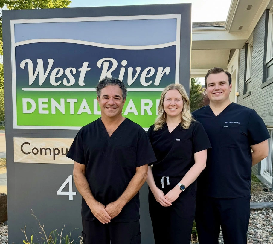 West River Dental Care doctors standing by the office sign