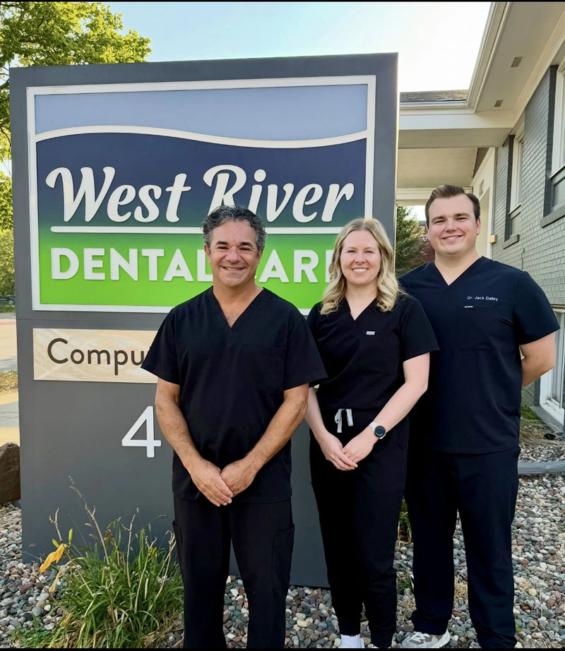 Dental team standing in front of West River Dental Care office sign